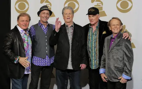 Fem leende medlemmar av The Beach Boys poserar för ett foto.