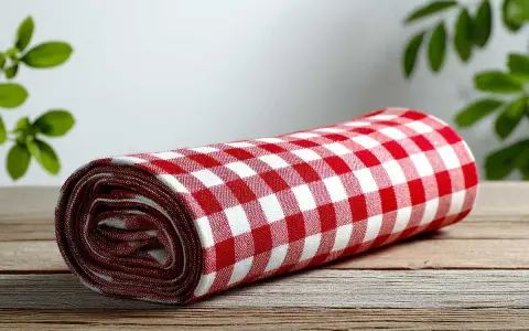 Tovaglia a quadri rossi e bianchi arrotolata su un tavolo di legno. Cos'è la fantasia? È l'immaginazione che crea scenari, come un picnic in un prato.