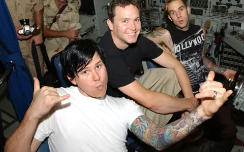 Mark Hoppus, Tom DeLonge och Travis Barker från Blink-182 i Sverige. De poserar med tatueringar och glada miner.