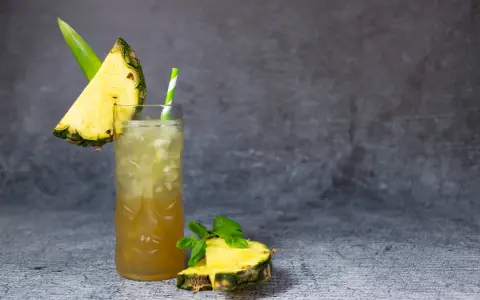 Klasyczny Mai Tai z sokami, ozdobiony kawałkiem ananasa i miętą. Idealny na tropikalny wieczór.