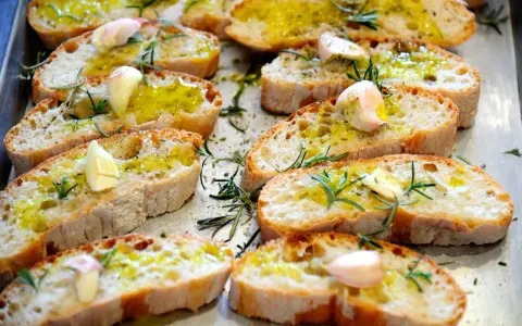 Fettunta toscana: fette di pane abbrustolito condite con olio d'oliva, aglio e rosmarino. Un classico antipasto toscano.