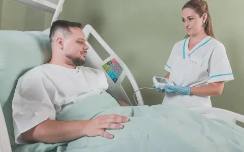 Pielęgniarka bada pacjenta w szpitalu. Walka z rakiem i nowotworem wymaga wsparcia medycznego.