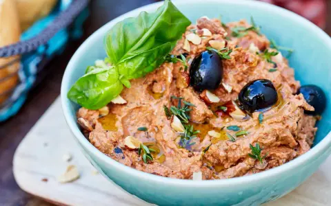 Herzhafte Dip Rezepte: Cremiger Dip mit Oliven, Mandeln und Basilikum, beträufelt mit Olivenöl. Perfekt zum Dippen!