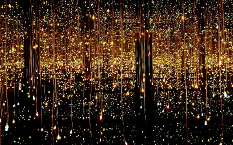 Salle miroir à l'infini, des lucioles scintillent sur l'eau, créant un spectacle lumineux enchanteur.