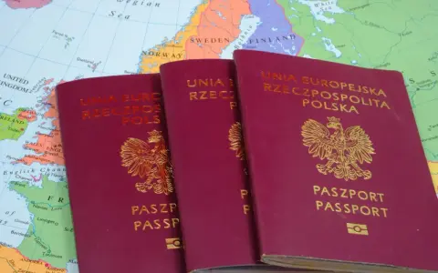 Trzy polskie paszporty leżą na mapie Europy. Czy do Grecji potrzebny jest paszport? Tak, jeśli podróżujesz spoza strefy Schengen.