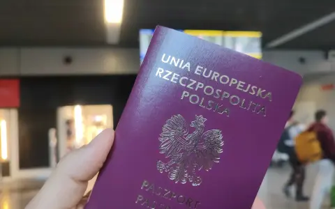 Polski paszport w dłoni, gotowy do podróży. Czy do UK potrzebny jest paszport? Tak, dla obywateli UE jest wymagany.