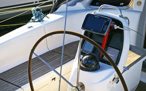 Cockpit de voilier avec barre, compas et écran Raymarine. Idéal pour un gps marine gratuit pour Android.