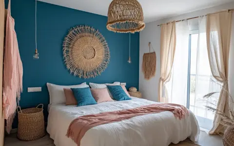 Chambre avec deco bleu canard et bois. Un grand soleil mural en paille, coussins bleus et roses, et un plaid pêche sur le lit.