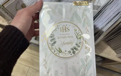 Chrzestny szuka idealnego prezentu. Elegancka pamiątka Komunii Świętej dla dziewczynki, ozdobiona złotymi gałązkami i kryształkami.