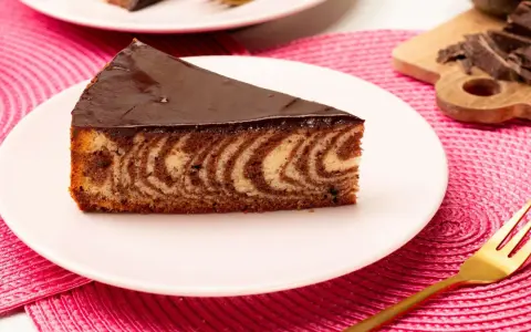 Ein Stück saftiger Zebrakuchen mit Schokoladenglasur auf einem Teller. Dieses Zebrakuchen Rezept ist ein Klassiker.