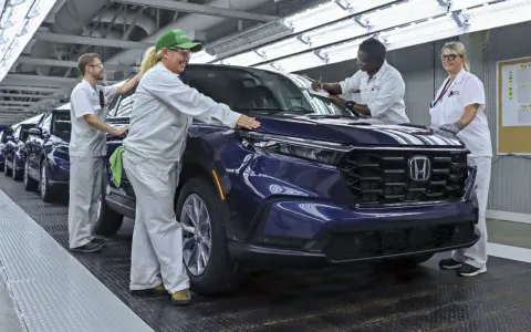 Pracownicy w fabryce Hondy z Japonii kontrolują nowy, ciemnoniebieski SUV.