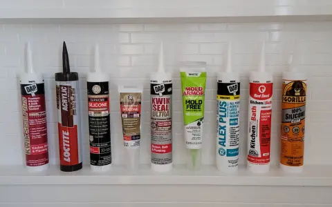 A variety of caulking tubes are lined up, ready for anyone wanting to learn how to caulk a shower. Brands include DAP, Loctite, GE, Mold Armor, Alex Plus, Red Devil, and Gorilla.