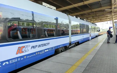 Pociąg PKP Intercity na peronie, z widocznymi oknami i logo przewoźnika.