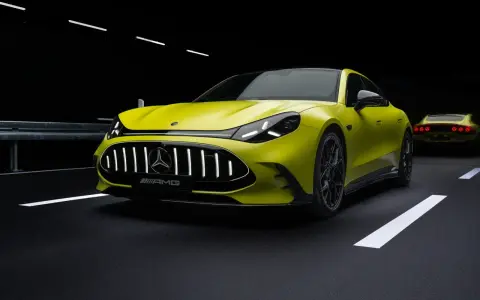 Ein leuchtend gelber AMG Elektro-Sportwagen mit beleuchtetem Kühlergrill steht auf dunklem Asphalt.