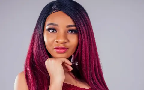 Una giovane donna con capelli color prugna, un look audace che le sta benissimo.