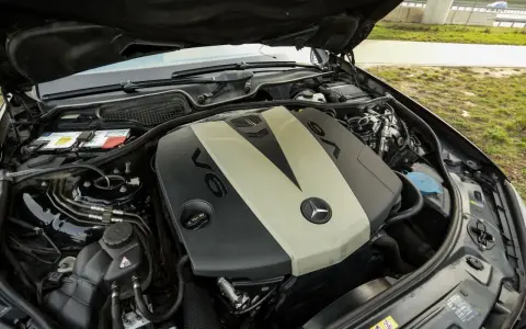 Silnik V6 om642 Mercedesa z otwartą maską. Widoczny akumulator, płyny i elementy osprzętu.