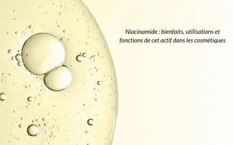 Gouttes dans un liquide clair, évoquant la pureté et les bienfaits de la niacinamide pour la peau.