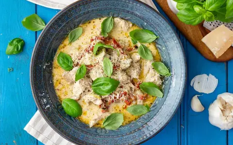 Krämig kyckling med soltorkade tomater, toppad med färsk basilika och parmesan. En härlig rätt som doftar Italien.