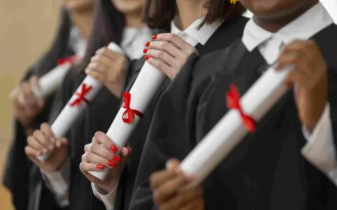 Graduados celebran el fin de su etapa para estudiar un MBA, sosteniendo sus diplomas con cintas rojas.