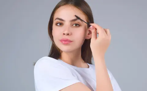 Jeune femme se brossant les sourcils. Une préoccupation pour la perte de sourcils avec l'âge, mais ici, ils sont parfaits.