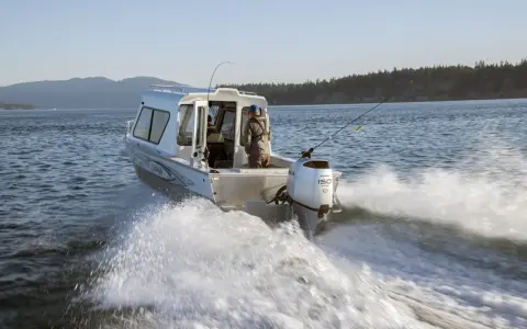 Bateau de pêche en mer avec moteur hors-bord Honda 150 CV 4 temps, offrant une navigation fluide.