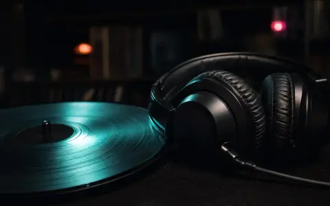 Schwarze Kopfhörer neben einer Vinylplatte, ideal für indie musik beispiele. Im Hintergrund Regale voller Platten.