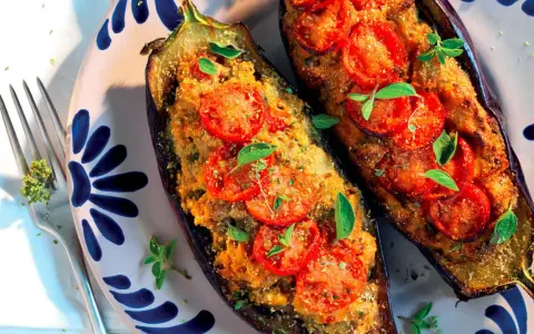 Melanzane ripiene pugliesi, gustose e profumate, con pomodoro e basilico fresco, pronte per essere gustate.