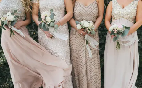 Brautjungfern in eleganten Kleidern mit Blumensträußen. Inspiration, was zieht man zur Hochzeit an als Gast Frau.
