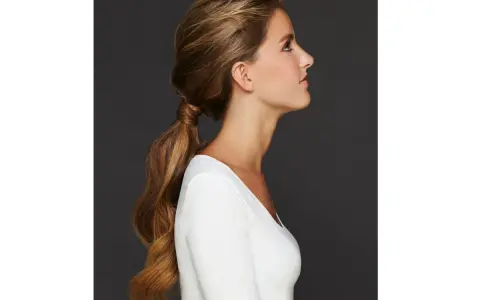 Capelli lunghi e mossi raccolti in una coda bassa, un'idea per semplici acconciature matrimonio invitata.