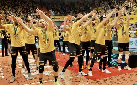 Drużyna MKS Lublin świętuje zwycięstwo na boisku, otoczona konfetti i wiwatującymi kibicami.