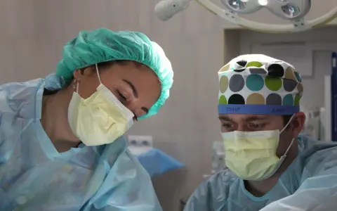Chirurdzy w maskach i czepkach analizują sytuację po laserowym usunięciu prostaty, rozważając potencjalne powikłania.