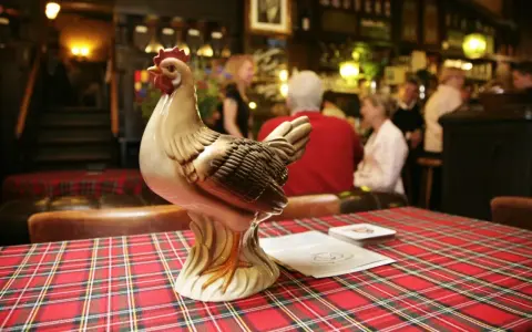 Keramikhähnchen auf kariertem Tisch in uriger Berliner Kneipe.