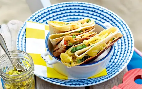 Leckeres Quesadillas Rezept: goldbraune Tortillas gefüllt mit geschmolzenem Käse und Frühlingszwiebeln, serviert in einer Schüssel.