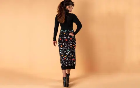 Mujer con falda lápiz negra estampada con flores de colores. Un ejemplo de los diversos tipos de faldas.