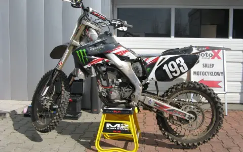 Motocykl crossowy na stojaku. Pytanie: co ile wymieniać filtr powietrza w motocyklu? Regularna konserwacja to klucz do mocy!