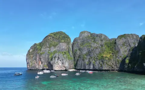 Traumhafte Felsformationen und türkisfarbenes Wasser laden zum Segeln in Thailand ein. Boote ankern in der Bucht.