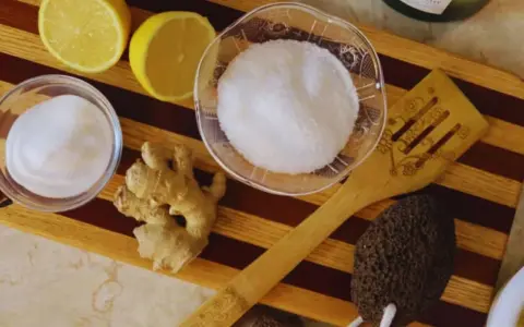 Ingredients for a homemade foot soak to remove dead skin: lemons, ginger, sugar, and a pumice stone.