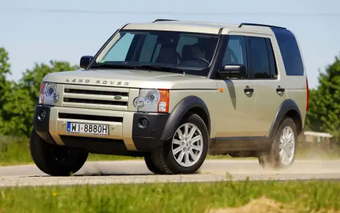 Złoty Land Rover Discovery 3 w ruchu, unoszący kurz. Temat: land rover discovery 3 awarie i problemy.