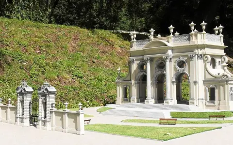 Miniaturowa budowla z kolumnami i bramą, jak w parku miniatur województwa mazowieckiego.
