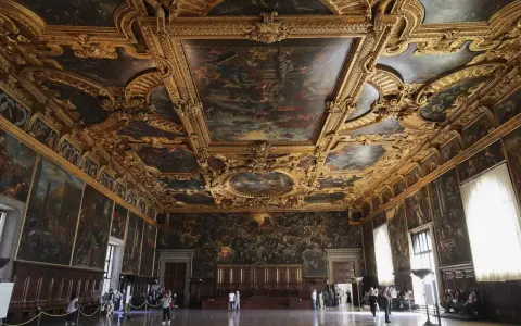 La salle du grand conseil du palais des doges, un chef-d'œuvre orné de peintures et de dorures, accueille des visiteurs émerveillés.