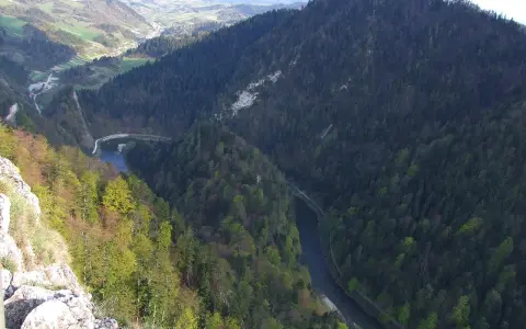 Widok z góry na malownicze góry z przełomem Dunajca, otoczone gęstym lasem i zielonymi dolinami.