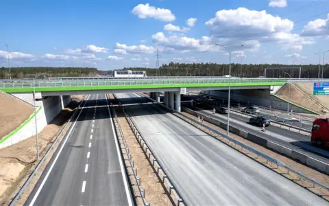 Nowa autostrada A6 z zielonym wiaduktem i ruchem samochodowym.
