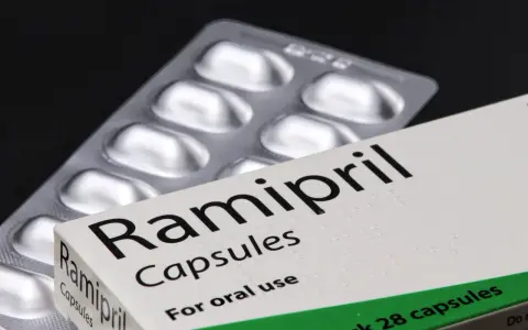 Ramipril kapsułki na nadciśnienie. Opakowanie leku i blister z tabletkami na czarnym tle.