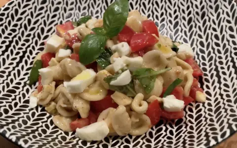 Orecchiette alla crudaiola con pomodorini, mozzarella e basilico fresco, un piatto estivo colorato e saporito.