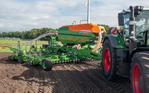 Nowoczesny siewnik Amazone Cirrus 8004-2C z ciągnikiem na polu, przygotowujący ścieżki technologiczne.