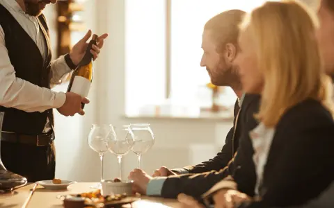 Ein Sommelier präsentiert eine Weinflasche. Die Bedeutung eines Sommeliers liegt in der Weinberatung und -auswahl.