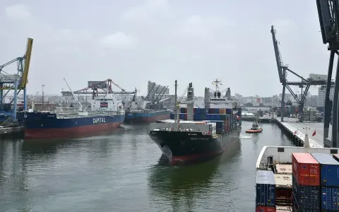 Navi da carico e gru nel porto di Casablanca. Un rimorchiatore assiste una nave portacontainer.