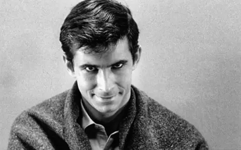 Primo piano di un uomo con un'espressione inquietante, un'icona del cinema psycho di Gus Van Sant.