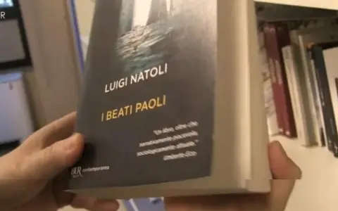 Mani che sfogliano "I Beati Paoli" di Luigi Natoli, un libro che promette narrazione avvincente e analisi sociologica.