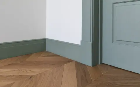 Elegancka listwa przypodłogowa w kolorze miętowym, z widocznymi wymiarami, idealnie komponuje się z drewnianą podłogą ułożoną we wzór jodełki.